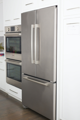 Refrigerator and double oven in kitchen side view