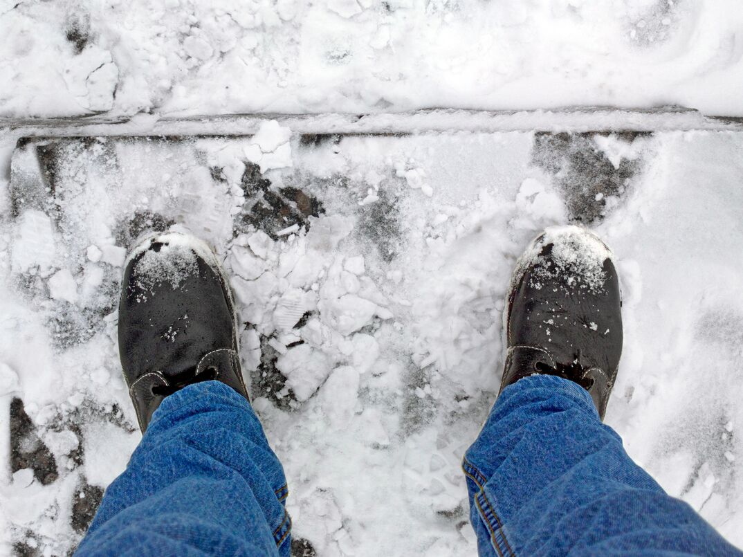 man's boots on frozen concrete steps