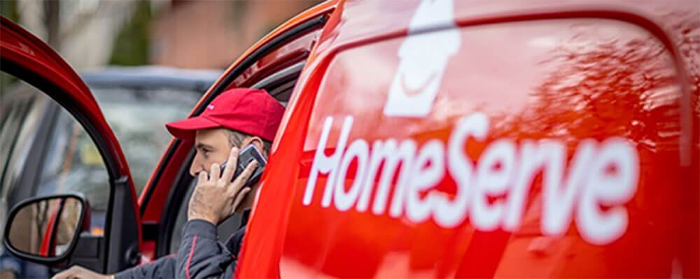 Employee getting out of HomeServe van on his phone