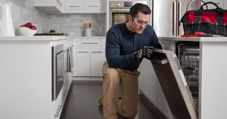 Professional technician working on fixing dishwasher